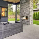 Outdoor patio with a stone fireplace and seating area