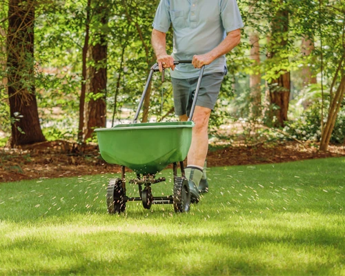 Landscaper fertilizing a lawn